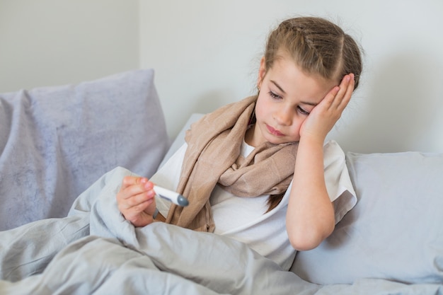 Free Photo ill girl using thermometer