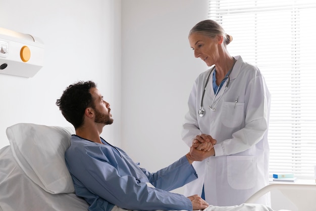 Free photo ill male patient in bed talking to a nurse