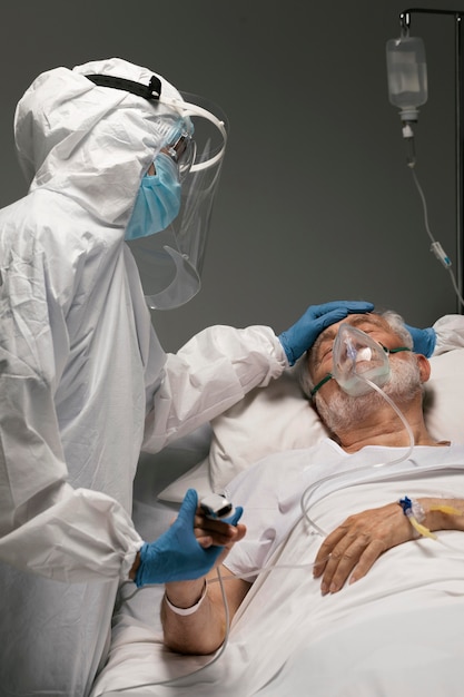 Ill man with respirator holding hands with a doctor