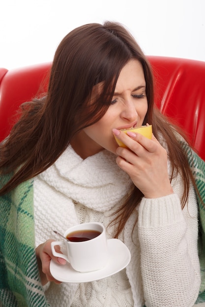 Ill young woman biting a bitter lemon