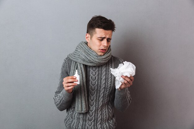 Illness man wearing warm scarf standing isolated