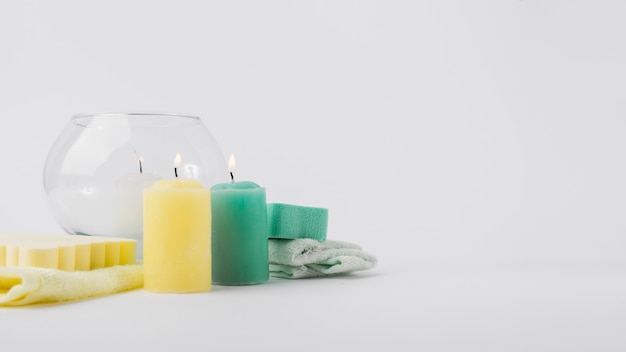 Illuminated colorful candles with sponge and napkin isolated over white background