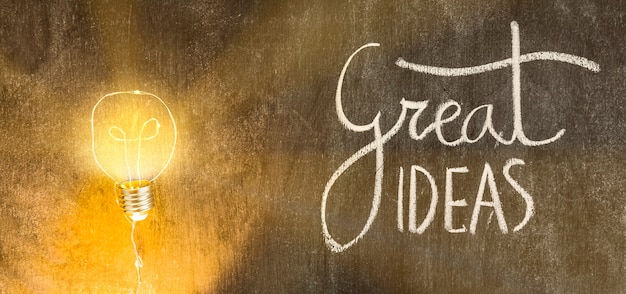 Free photo illuminated light bulb with great ideas text written on chalkboard