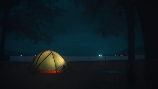 Free photo illuminated tent on the beach under the beautiful mysterious night sky