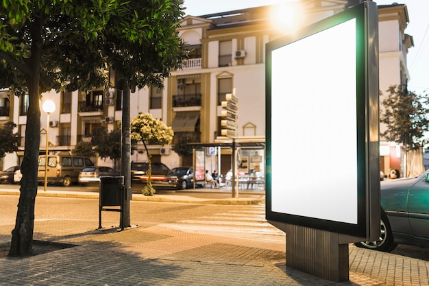 Illuminated white blank billboard on the roadside