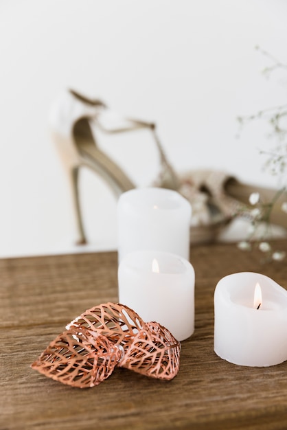 Free photo an illuminated white candles on wooden table