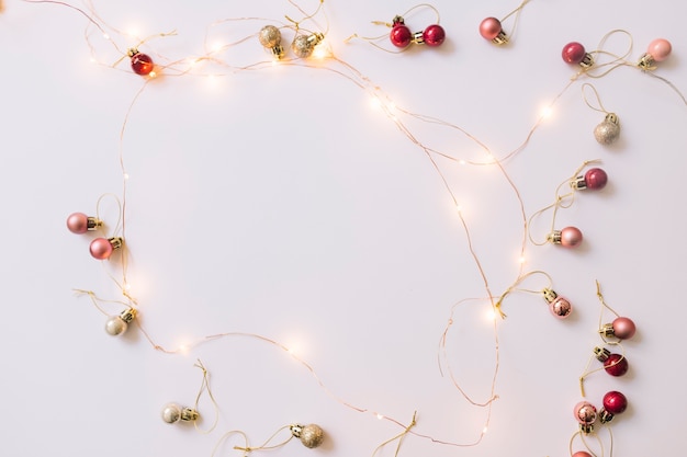 Free photo illuminating fairy lights near christmas baubles