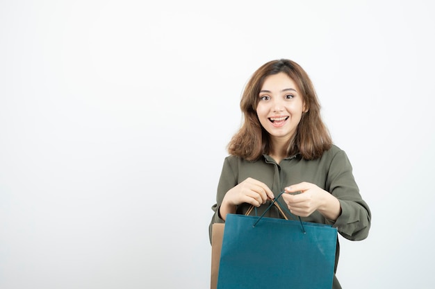 Image of beautiful short-haired girl with shopping bags standing. High quality photo