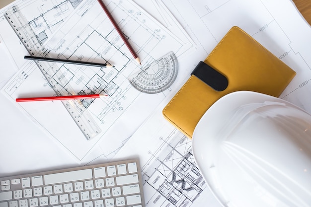 Image of blueprints with level pencil and hard hat on table