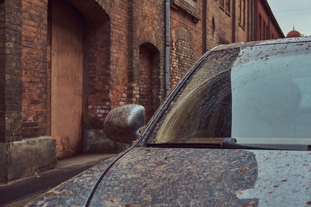 Image of a dirty car after a trip off-road. Stands against a brick wall in the old part of town.