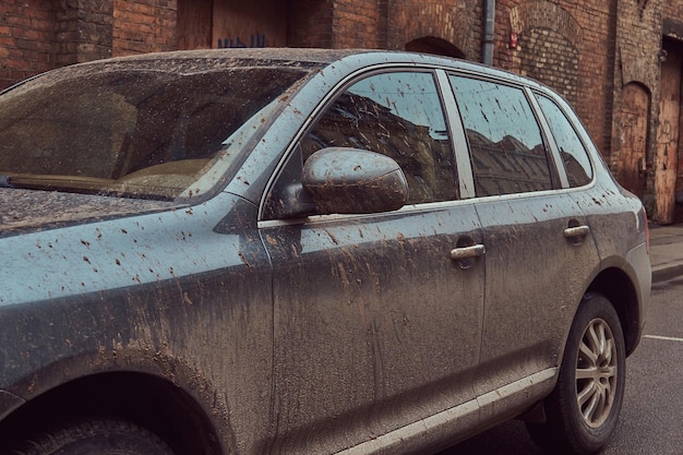 Image of a dirty car after a trip off-road. Stands against a brick wall in the old part of town.