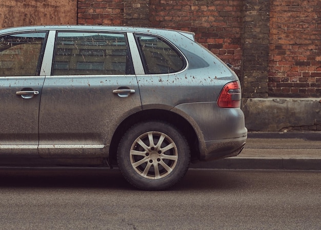 Free photo image of a dirty car after a trip off-road. stands against a brick wall in the old part of town.