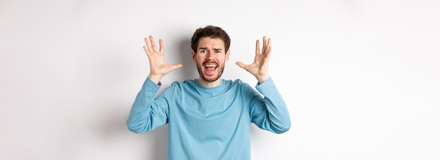 Free Photo image of freaked out young man screaming and shaking hands shouting at camera frustrated or worried