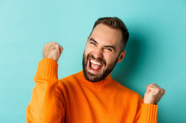 Free photo image of handsome relieved man feeling satisfaction, rejoicing of winning or achievement