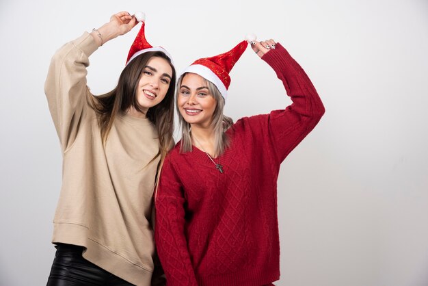 Image of a happy women holding a Santa hats .