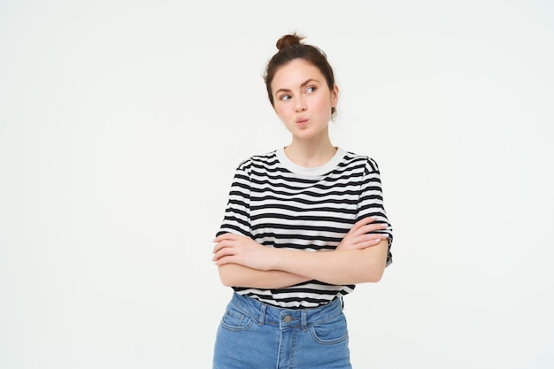 Free photo image of intrigued young woman thinking pucker lips with thoughtful face cross arms on chest