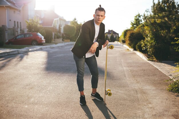 Image of a man with longboard going on road