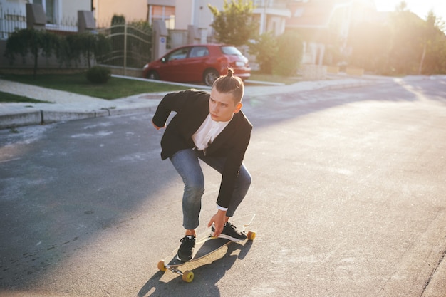 Image of a man with longboard going on road