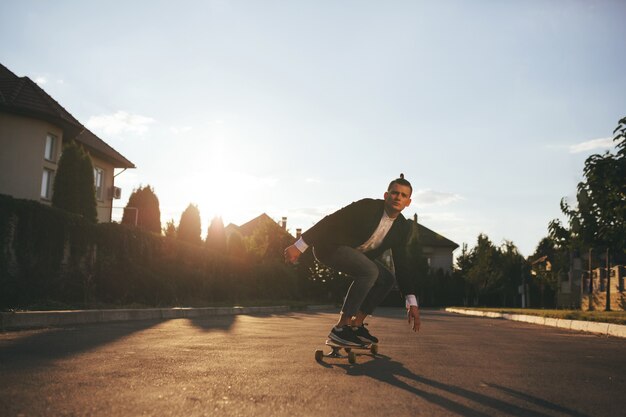 Image of a man with longboard going on road