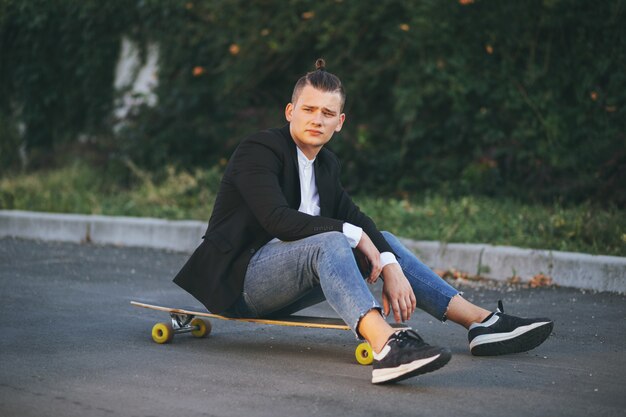 Image of a man with longboard going on road