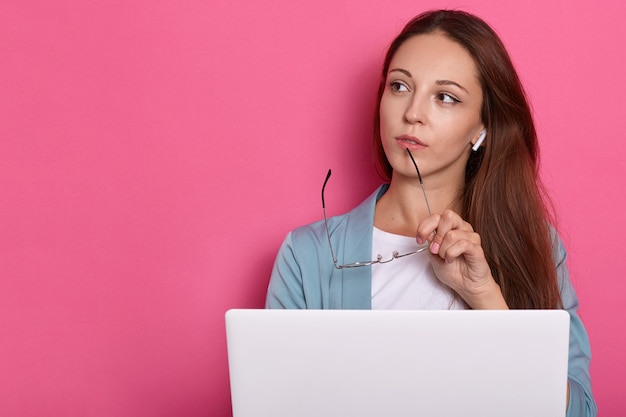 Free photo image of pensive female posing against rosy wall.