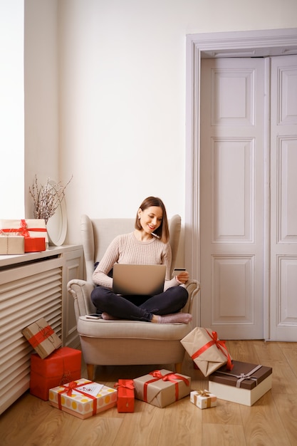 Image of pleased nice woman holding credit card with copy space using laptop