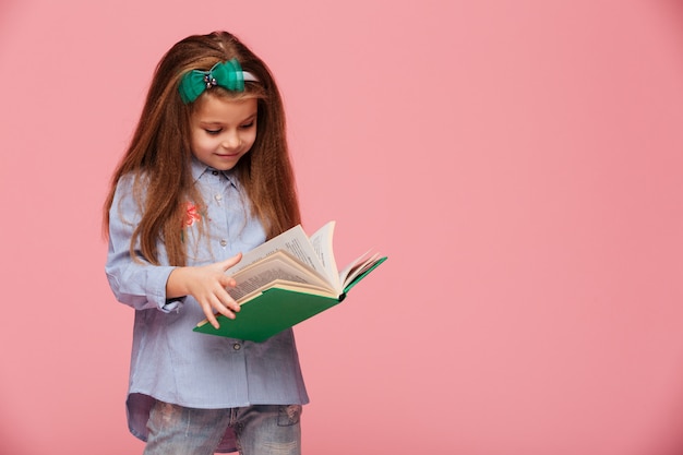 Image of smart schoolgirl with long auburn hair reading interesting book