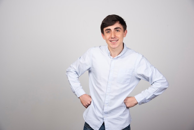 Image of a smiling man model standing and posing with hands on hips