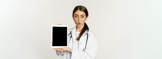 Free Photo image of woman doctor female healthcare worker showing online medical website digital tablet screen