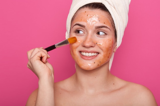 Image of woman holding brush for applying cream