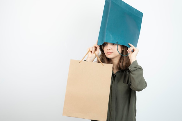 Free photo image of young girl getting her head inside of craft bag. high quality photo