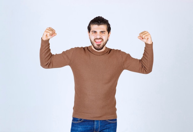 Image of a young handsome man standing and showing his muscles. High quality photo