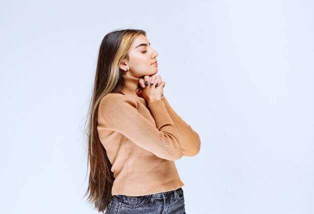 Image of a young woman model in brown sweater standing and posing.