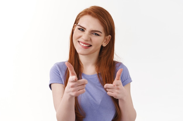 Impressed and satisfied pretty redhead woman, pointing finger pistols and smiling astonished, congratulate friend well done, praise good effort, white wall