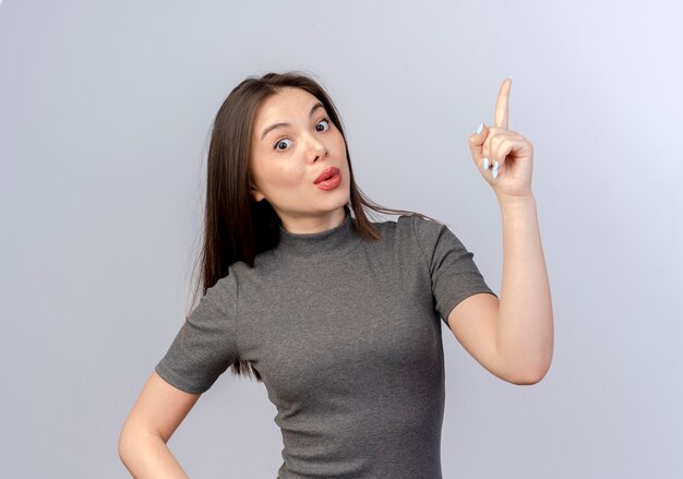 Impressed young pretty woman pointing up looking at camera isolated on white background