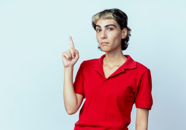 impressed young woman with pixie haircut pointing up