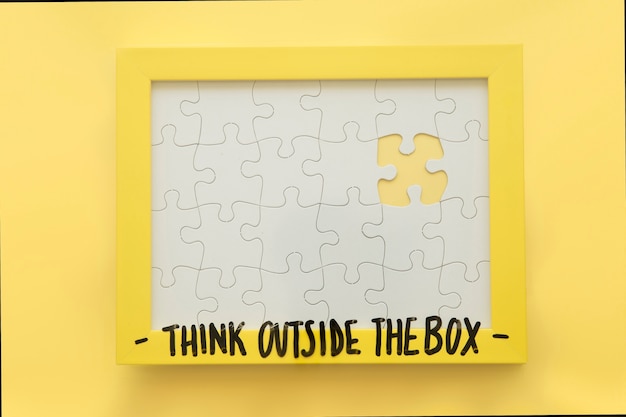 Free Photo incomplete jigsaw puzzle frame with think outside the box message