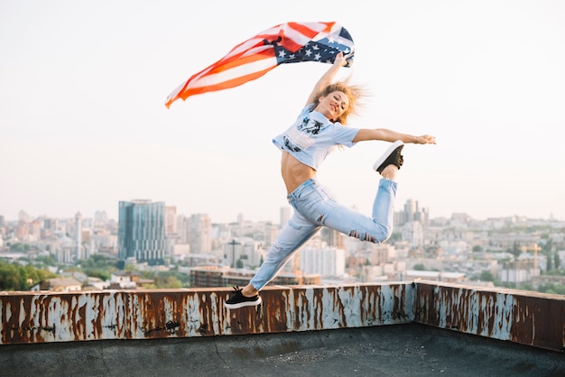 Free photo independence day concept with girl jumping on rooftop