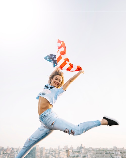 Free photo independence day concept with girl jumping on rooftop