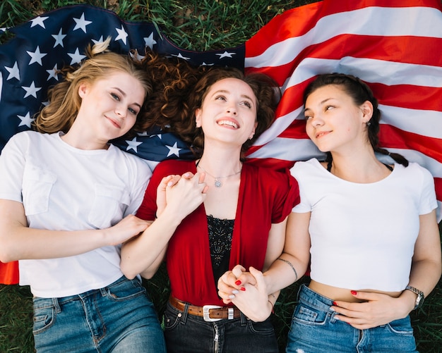 Independence day concept with girls lying on american flag