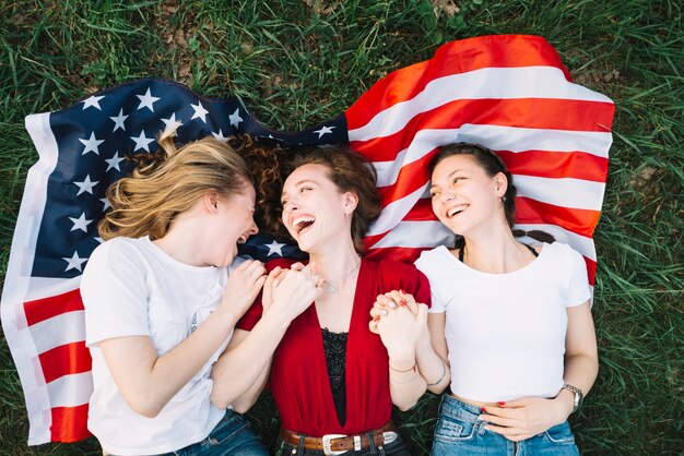 Independence day concept with girls lying on american flag