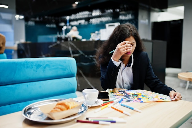 Indian artist woman wear formal paint picture while sitting at cafe