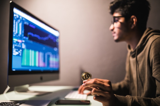 Free photo indian bitcoin trader checking stock trading data analysis concept working in office with financial graph on computer monitors