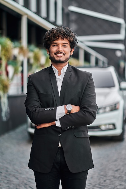 Free photo indian businessman with his white car.