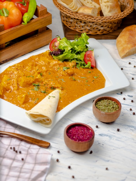 Indian curry with chicken breast and tomato sauce served with lavash. 