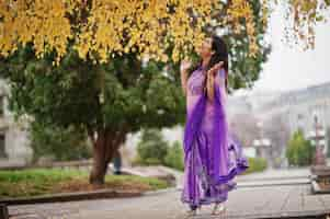 Free photo indian hindu girl at traditional violet saree posed at autumn street