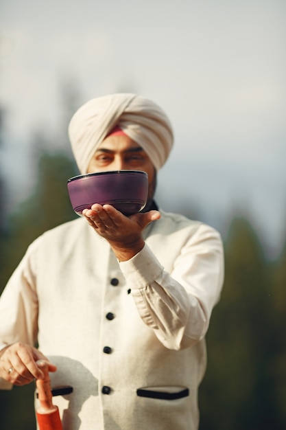 Indian man in a mountains. Male in a traditional turban. Hinduist with special things for rituals.