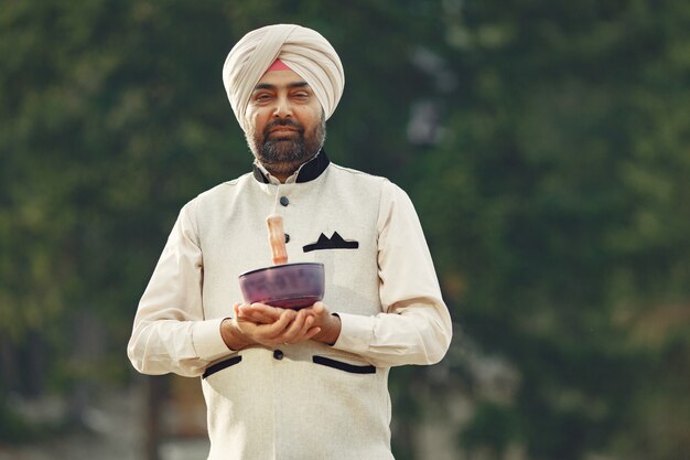 Indian man in a mountains. Male in a traditional turban. Hinduist with special things for rituals.