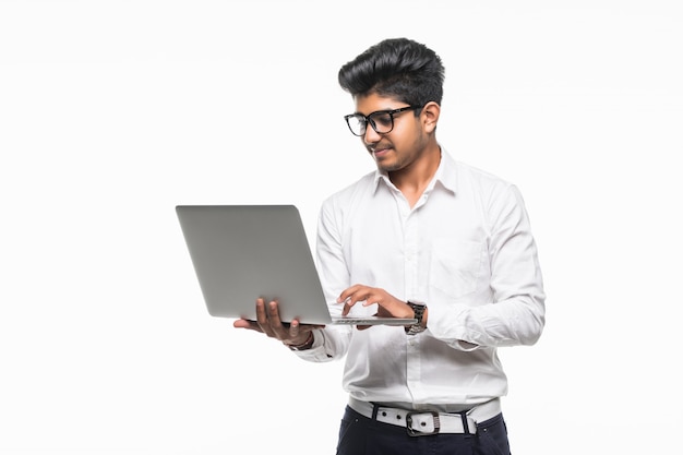 Indian young man with laptop isolated on white wall