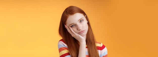 Free photo indifferent careless sleepy redhead silly female student lean palm looking bored uninterested listen